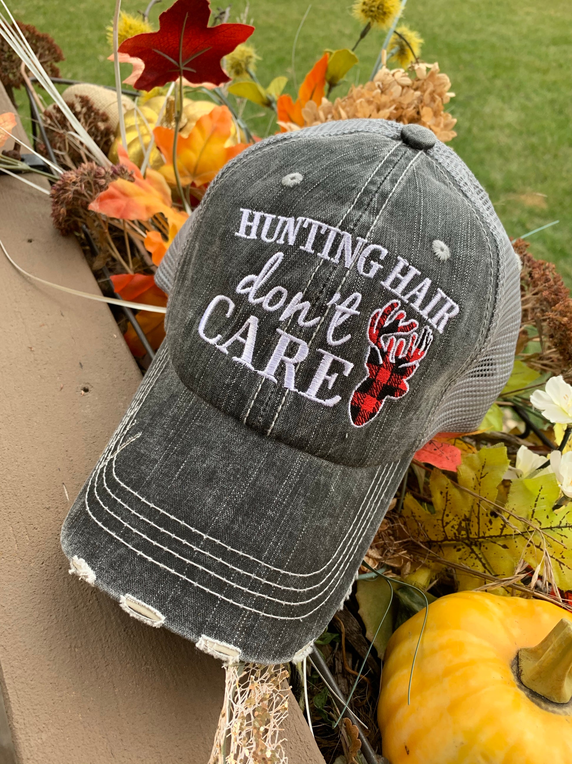 Hat { Hunting hair dont care } Gray with black and red buffalo plaid deer. Embroidered gray distressed trucker cap with adjustable Velcro and hole for pony. - Stacy's Pink Martini Boutique