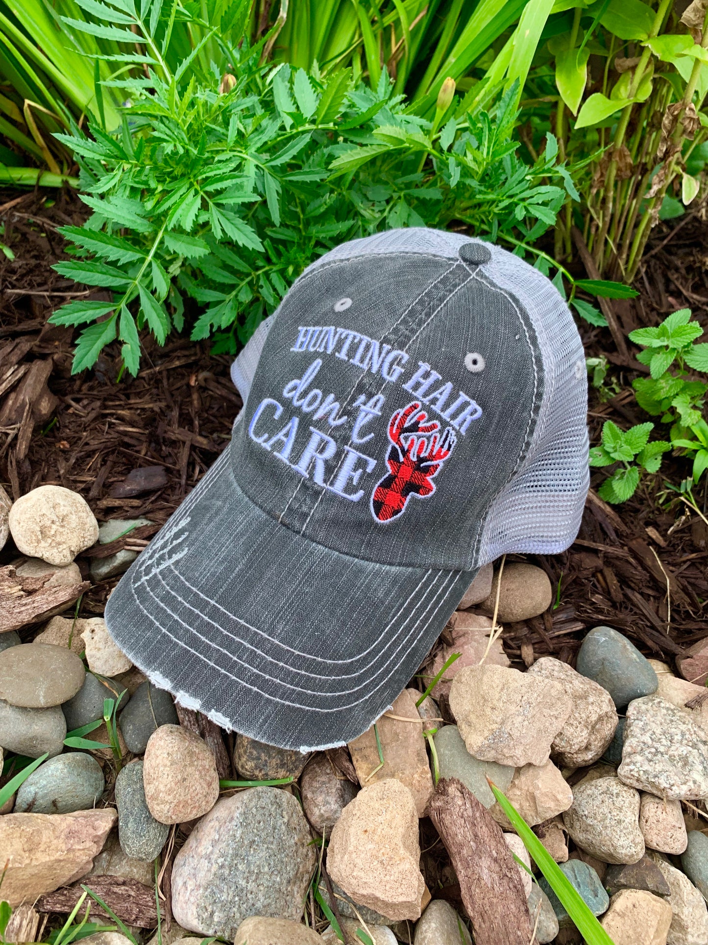 Hat { Hunting hair dont care } Gray with black and red buffalo plaid deer. Embroidered gray distressed trucker cap with adjustable Velcro and hole for pony. - Stacy's Pink Martini Boutique